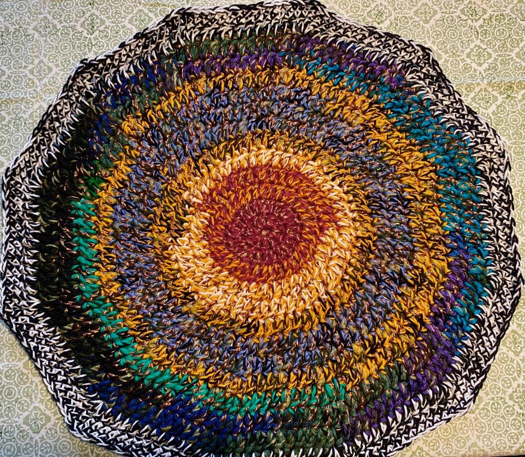 A crocheted round blanket. It's sort of round. A variety of yarns make it look cushiony. Basically, we should all be confused.